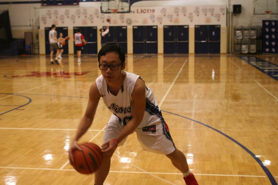 International senior Bill Huang practices his dribbling during his basketball practice.