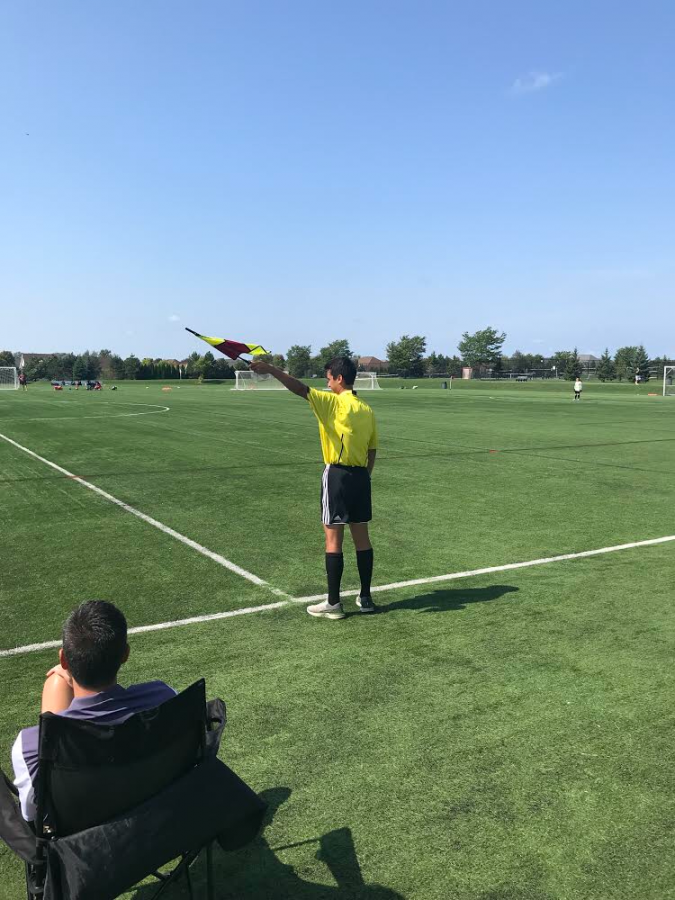 Sophomore Quentin Perry working as a referee at a soccer game.