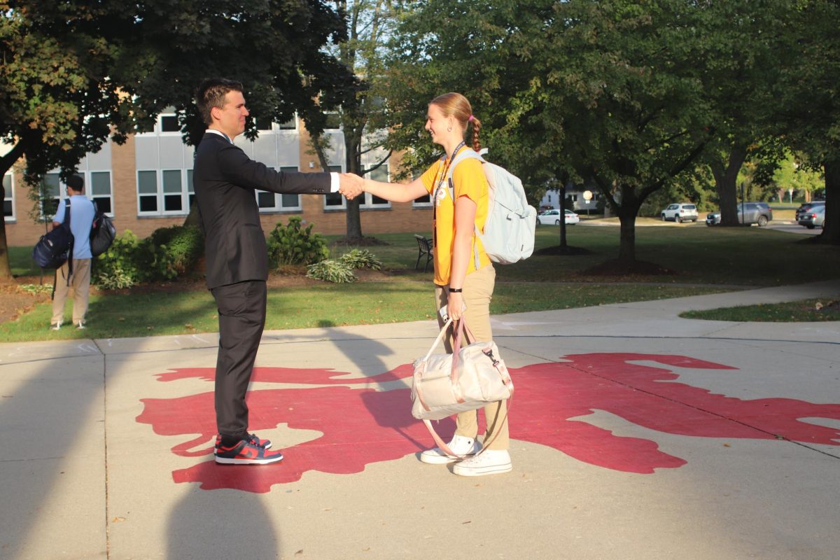 Mr. Aiello greets students on their way into the school.